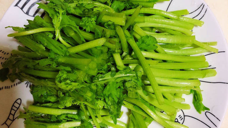 茼蒿炒肉丝,将根部切下来放入盘中,叶子部分单独放。