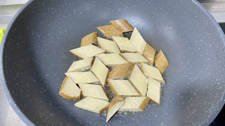 孜然煎豆干,锅中加适量食用油,油六成热,依次摆入豆干,中小火煎,