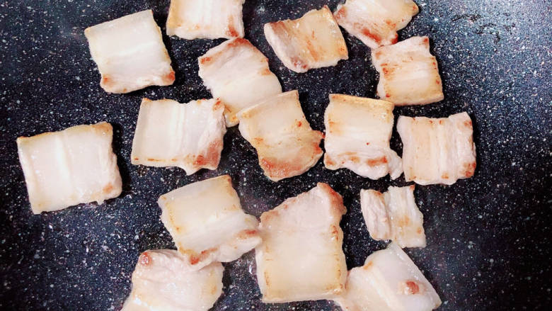 土豆回锅肉,锅中放入五花肉片,两面煎至金黄,练出猪油。