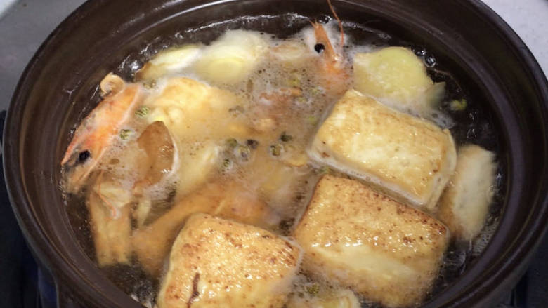 虾仁豆腐煲,倒入烧有热水的砂锅煲内,煮沸后再煮2分钟