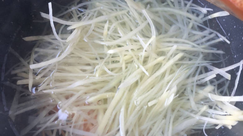 老干妈拌土豆丝,烧开一锅水,下入食材。