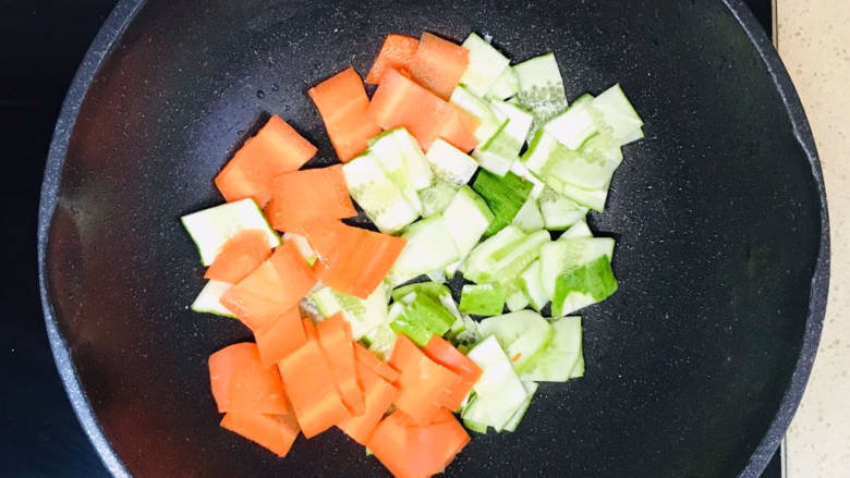 黄瓜烧豆腐,将蔬菜加入锅里,翻炒至蔬菜出水