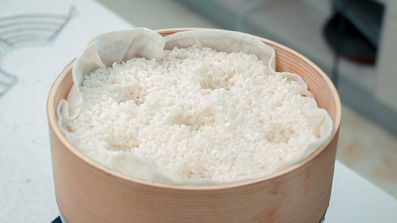 红枣切糕,蒸屉铺上纱布放入糯米,戳几个洞让蒸汽散发更均匀