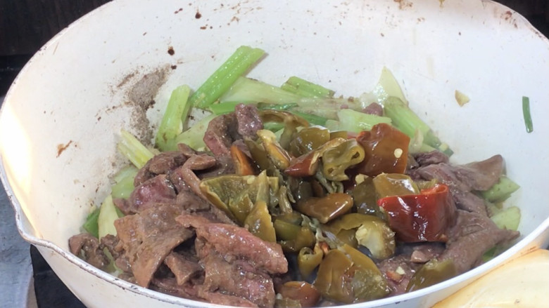 泡椒芹菜炒猪肝,放入猪肝和泡椒,翻炒均匀至入味
