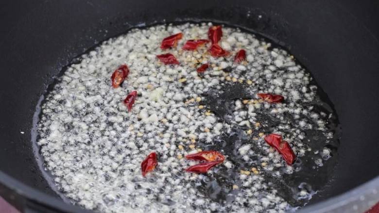 小炒毛豆,锅中倒入食用油烧热,下姜蒜末和红干椒小火炒出香味儿。