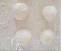 金枪鱼面包 ,发酵完成后取出排气,平均分割成7份,滚圆盖保鲜膜醒发15分钟;