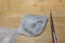 小米虾滑粥,将搅拌好的虾泥放入保鲜袋中,将保鲜袋的一个角剪一个开口(口的大小根据你需要的虾滑的大小决定);