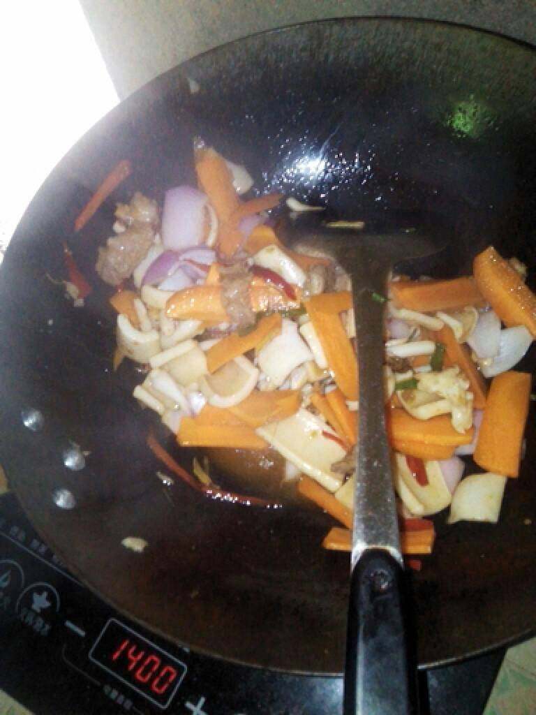 爆炒鱿鱼片,倒入胡萝卜和洋葱翻炒,加入盐、味精、胡椒粉等各种调料,