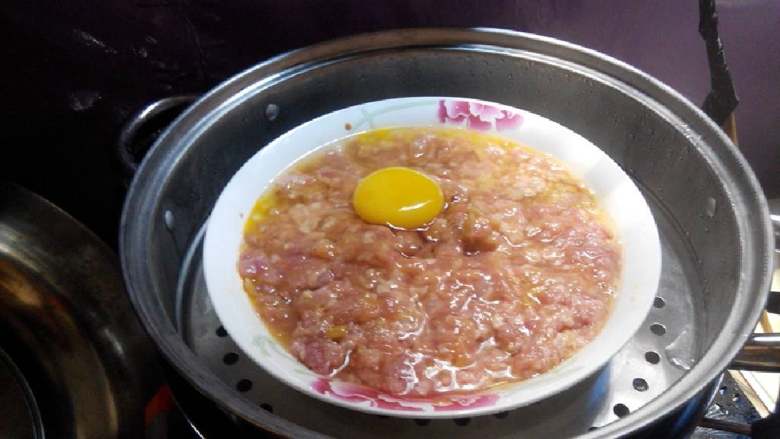 咸蛋蒸肉饼,开始上蒸锅蒸了,先在肉饼上用手指压四个浅坑,才放上鸡蛋,这样就不易走位。【蒸10分钟就可以了】
