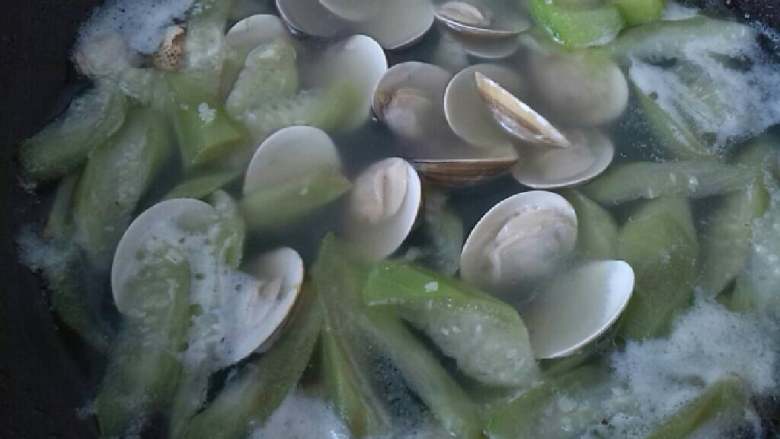 ≈丝瓜油蛤汤≈,接着倒入油蛤，加水大火煮开后转小火煮10分钟，最后调入盐即可