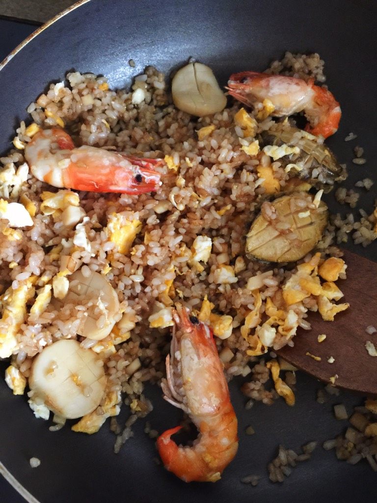 鲍鱼大虾炒饭,待饭粒炒至粒粒分开在油锅里跳舞，将辅料倒入一起煸炒