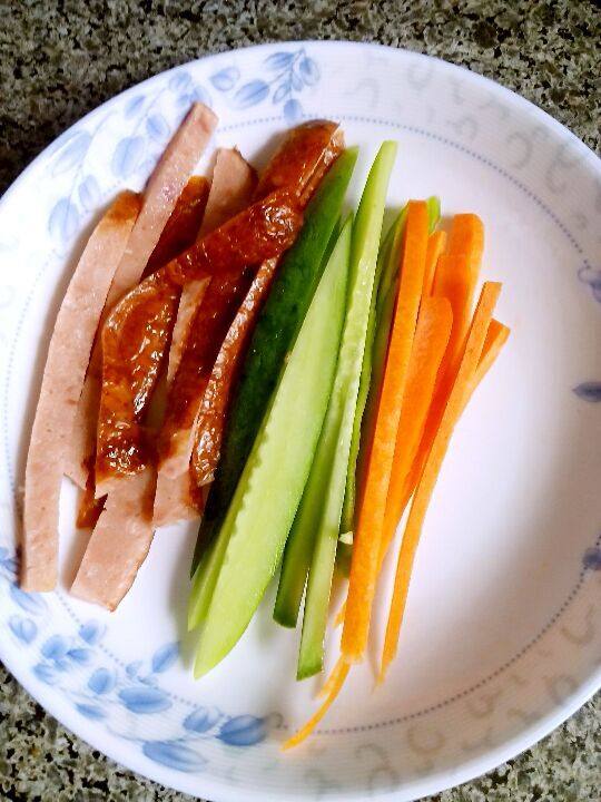 紫菜包饭—稻花香米,将所有材料切长条, 翻入锅中炒一下取出备用。鸡蛋饼煎好后, 宽切丝。