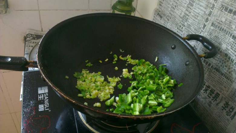 青椒炒河虾,锅内油倒出治净,再次淋入少许油烧热;放入葱花和青椒片儿炒香;