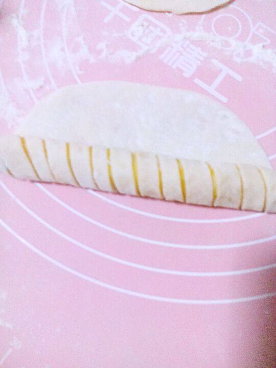 红薯环形面包,翻面,从一面卷起成长条状。