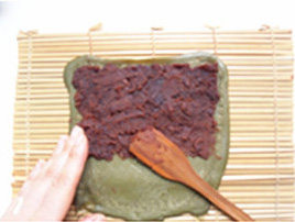 抹茶细沙水果卷,用木勺和手轻轻将豆沙抹在饼的上半部份;