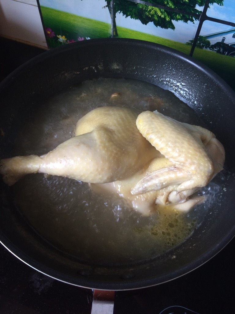 新疆美食【椒麻鸡】,如图三黄鸡比较肥可以用半煮半蒸的方式,在差不多八成熟的时候,在锅底放两根筷子将鸡撑起再煮二十分钟,此步骤可省略