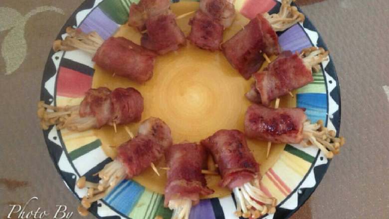 培根金针菇卷(平底锅版),培根变色。金针菇变软，差不多就可以了！煎好后出锅装盘