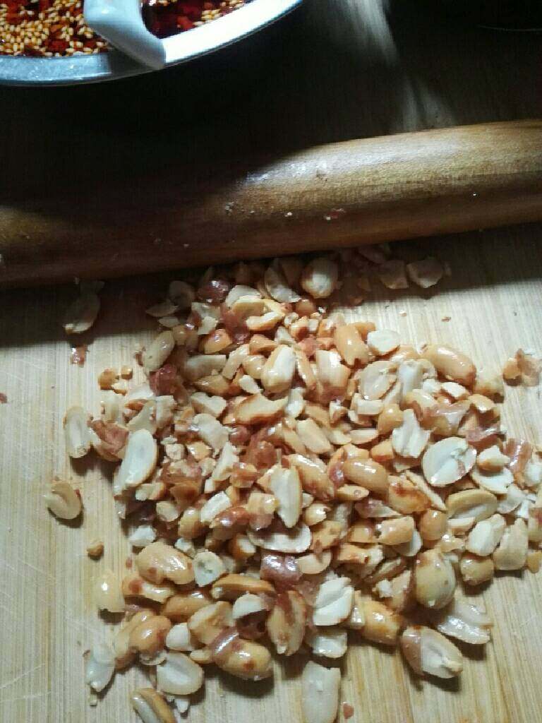 牛肉粒油辣椒,花生用油炸好.去皮,用擀面杖压碎。