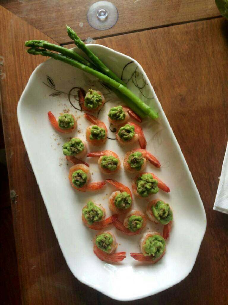 牛油果扑鲜虾,将煎好的虾球摆好盘，用塑料袋装牛油果泥挤在虾球上即可。（芦笋灼水后摆盘装饰）