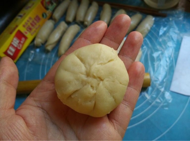 酥皮鲜肉月饼,如图将口捏紧,将肉饼轻轻按扁成月饼状,然后在中心用手指按压一下