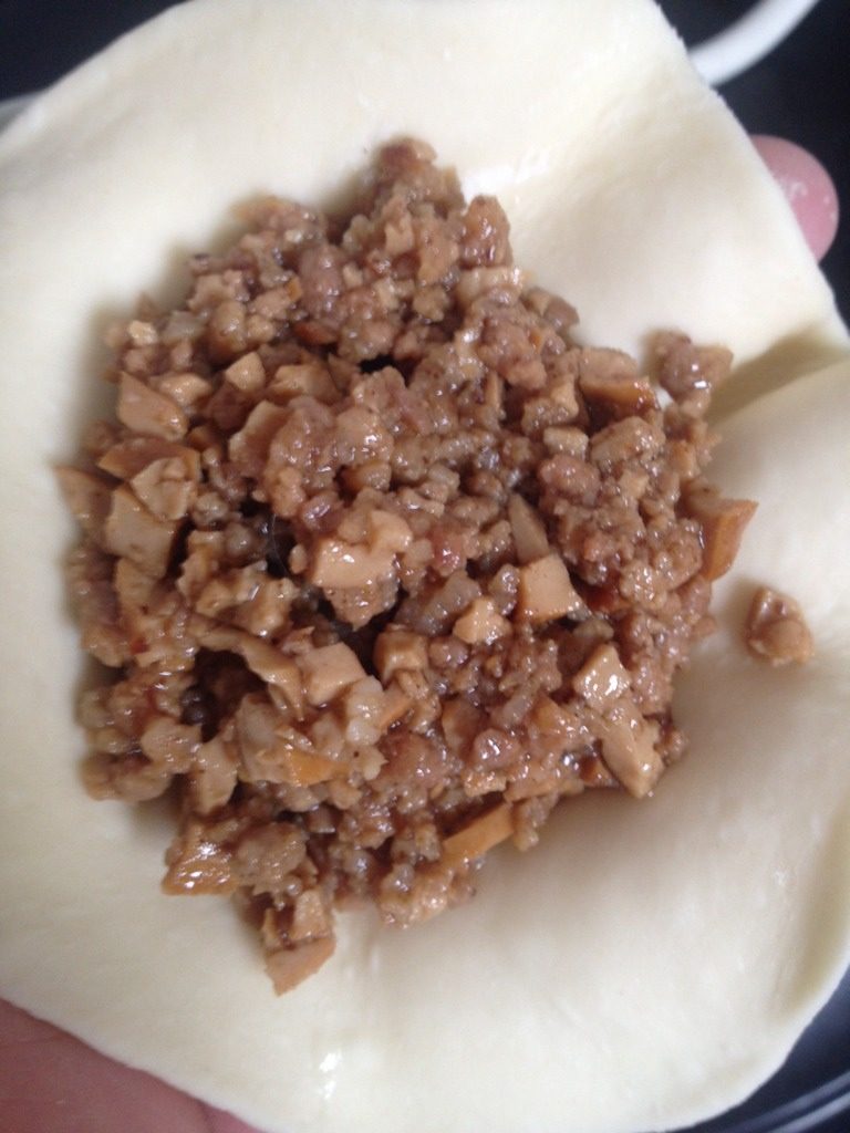 干豆腐猪肉大包,面团分成一个一个的小团，擀圆，放入炒好的馅（一定要等馅冷却后再包，等不及的可以在炒好馅后放入冰箱冷藏一小时），捏好褶子即可