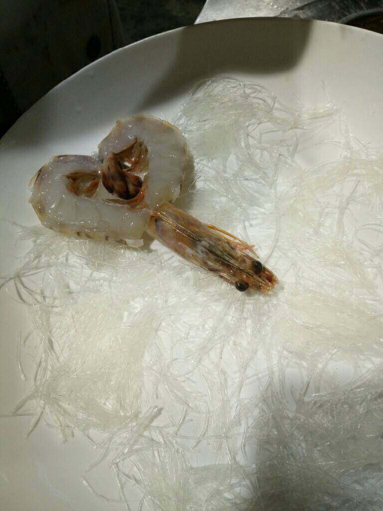 蒜蓉大虾,把粉丝段均匀铺在圆盘内,粉丝上面放大虾,如图所示这样摆得很有造型哦