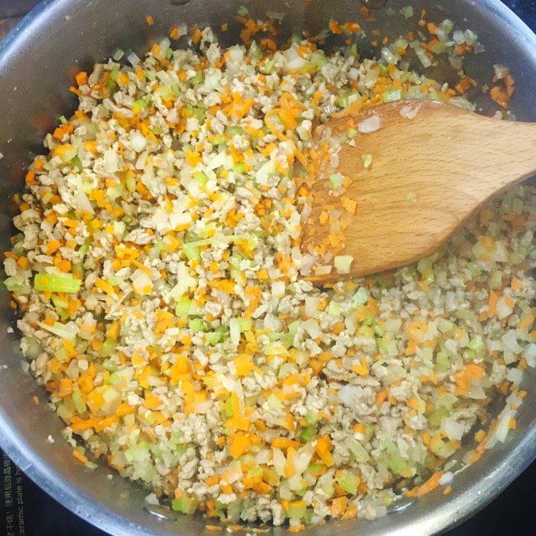 意大利肉酱意粉,锅内放入35ml橄榄油,下入牛肉粒煸炒。煸炒变色后放入胡萝卜、芹菜、洋葱一起煸炒。