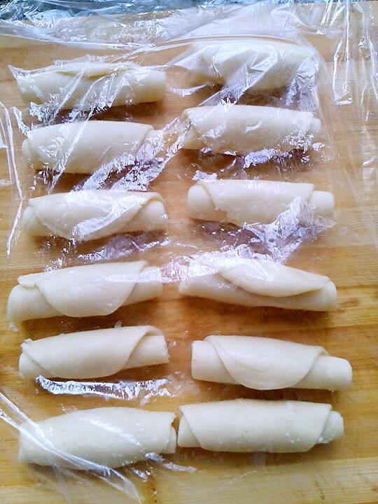 红薯馅月饼,把卷好的面团,用擀面杖擀成长椭圆形面片。再次把面片卷起来。盖保鲜膜静止一会。
