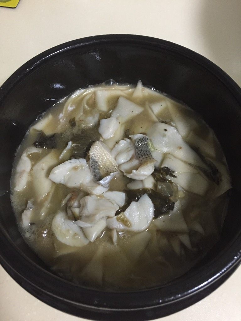 酸菜鱼刀削面片,如图石锅烧热,底部加入少许猪油,将烧好的酸菜鱼面片盛入石锅中,就可以了。