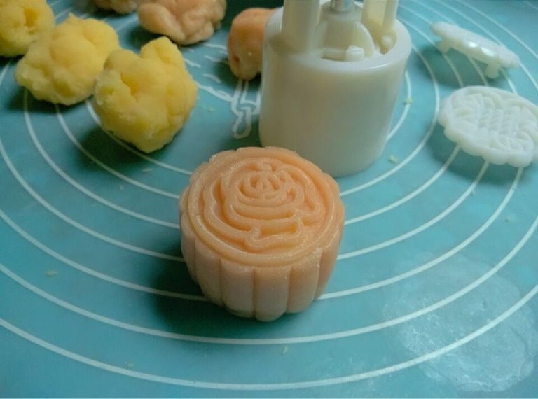 冰皮月饼,如图冰皮和馅儿各分25克一份,用冰皮包入馅儿揉圆,模具沾适量熟糯米粉再将多余的粉磕掉,将团放入模具内按压出自己喜爱的图案
