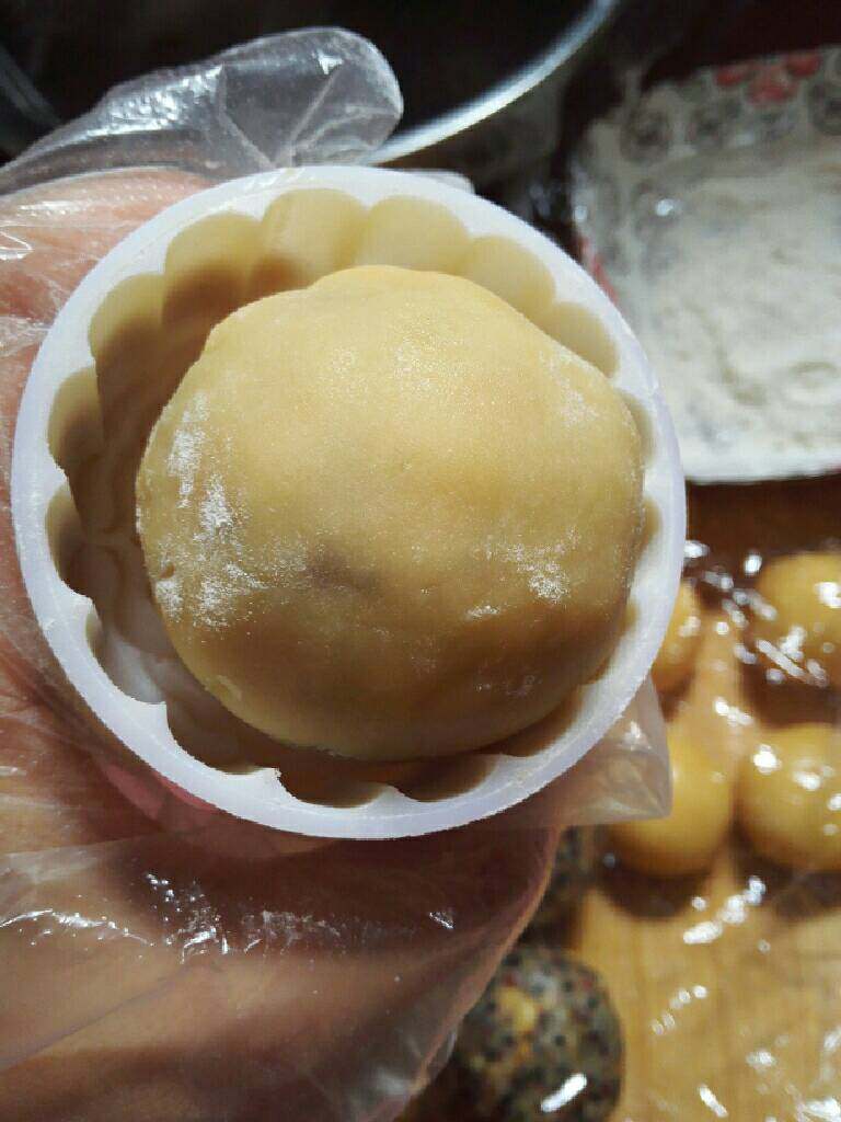 五仁月饼,模具沾一点油或滚一点玉米淀粉,把包好的面团放入月饼模具。