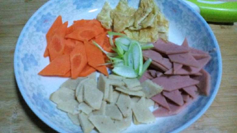 金沙河荞麦面片汤,将<a style='color:red;display:inline-block;' href='/shicai/ 25'>胡萝卜</a>，火腿，<a style='color:red;display:inline-block;' href='/shicai/ 335'>鱼丸</a>，蛋皮（蛋皮提前摊好）葱段切菱形片状备用。