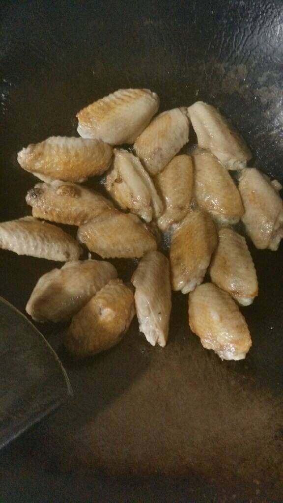 可乐鸡翅,锅中入油八成热时放入鸡翅煎至两面金黄