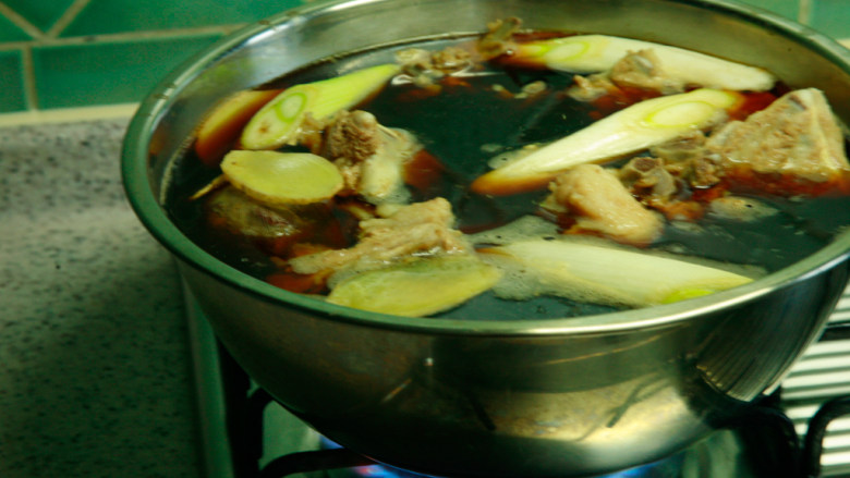 羊蝎子,配料入锅,入羊蝎子,入老抽、生抽、盐、糖,葱段姜片,大火烧开转小火2小时