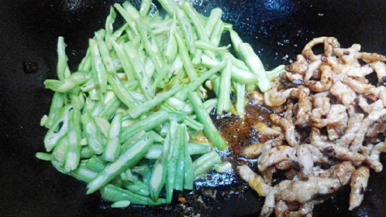 豆角肉丝拌面,把肉丝起锅一边，倒入豆角，豆角上调入适量盐，翻炒均匀