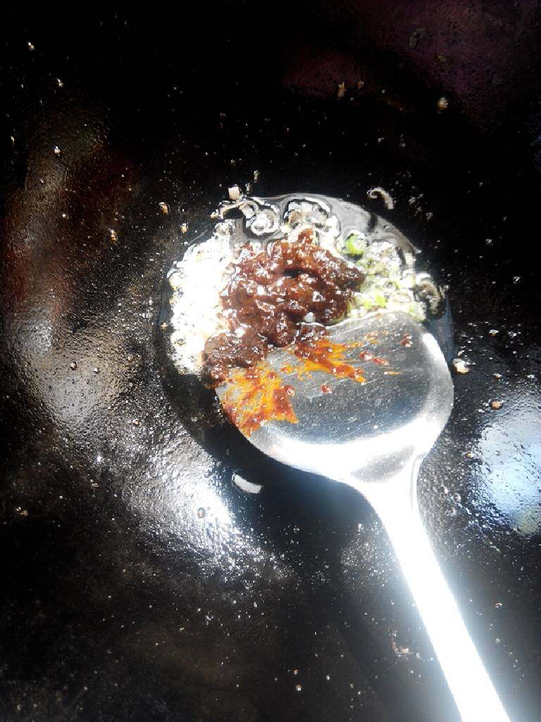 金沙河炸酱面,肉丁捞出，在煸出的油里放入葱花姜末炒香，放入酱翻炒。