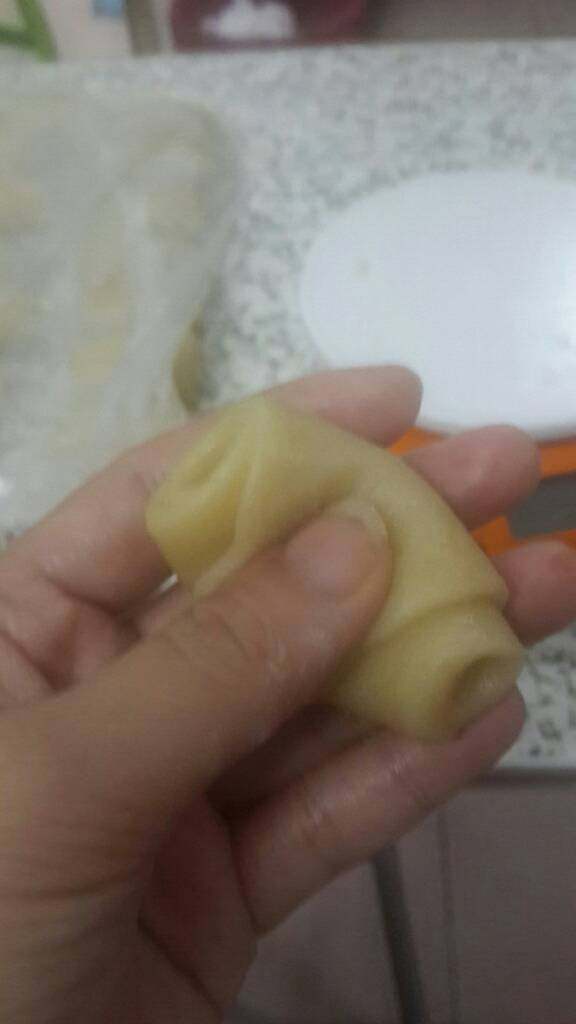 椰蓉开口酥,取一份酥皮,用手压成v型,将翘起的两头挨着