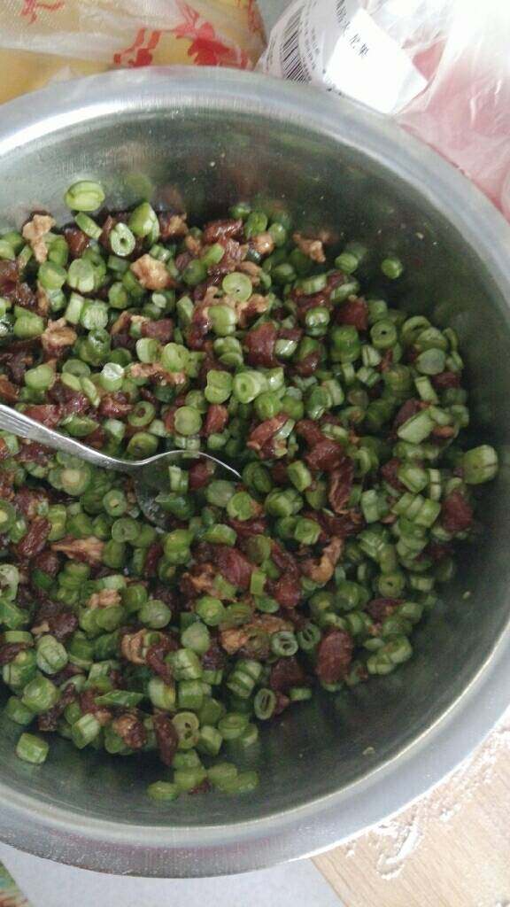 豆角猪肉包,再将豆角丁倒入拌均,加入盐拌均