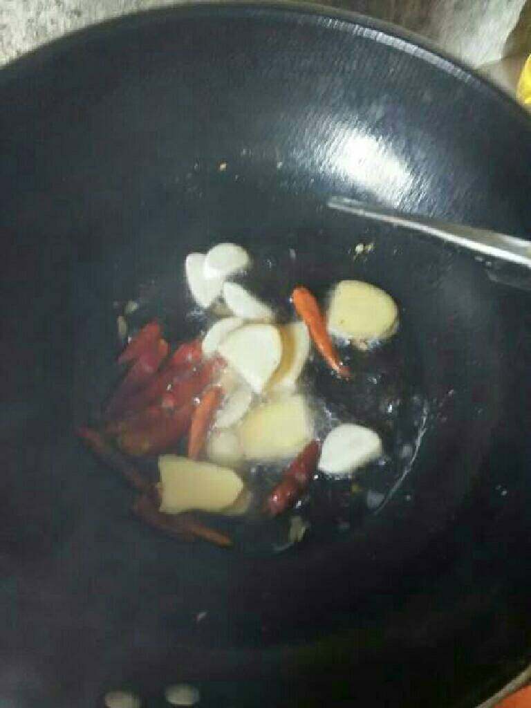 腊猪蹄炖萝卜,锅中油热,放入生姜,大蒜,辣椒炒香