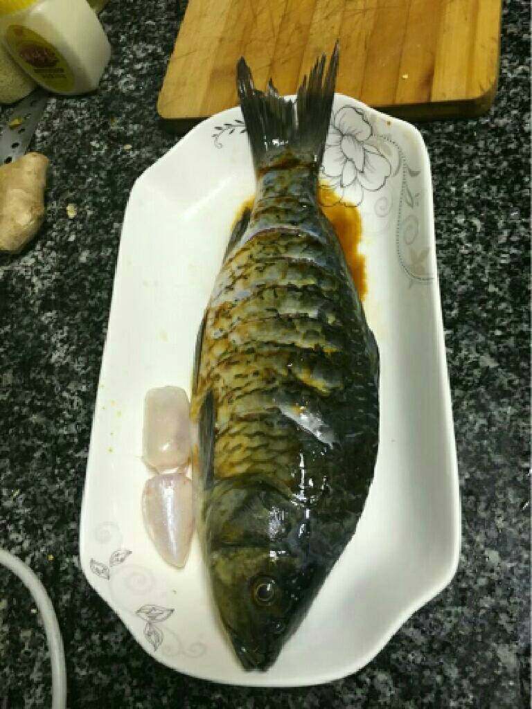 豆鼓蒸鲫鱼,
在鱼身上均匀撒上盐用手抹匀后准备三片姜塞进鱼肚中，随即淋上料酒，酱油抹匀后腌制十分钟。