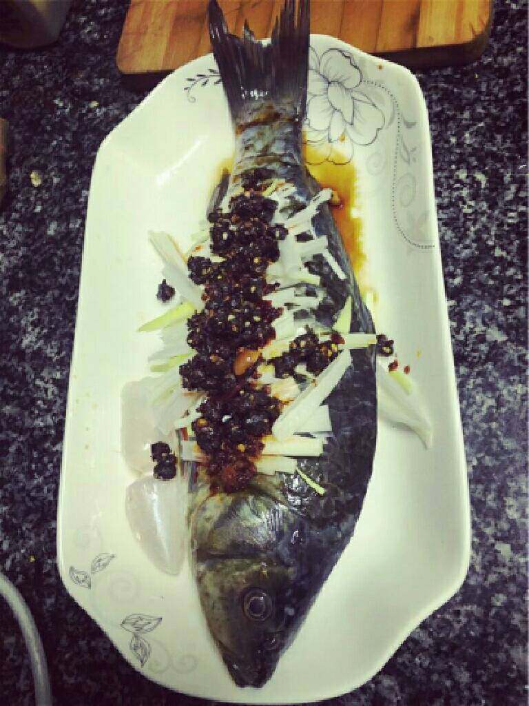 豆鼓蒸鲫鱼,蒸鱼
将大葱的葱白切成小条状，均匀铺在腌好的鱼上，再放上两勺豆豉抹匀。
