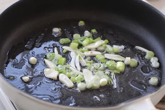 金针菇番茄汤,另起一锅倒适量食用油烧至五成热,放入葱花和蒜末小火炒出香味。