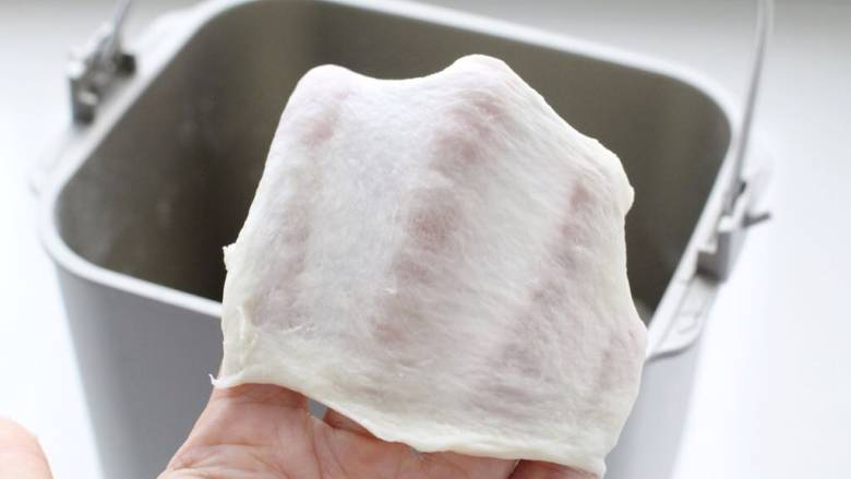 肉松牛角包,启动面包机揉面约15分钟,加入软化的黄油继续揉至完全扩展阶段,即取下一小块面团可以扯出薄膜状态。