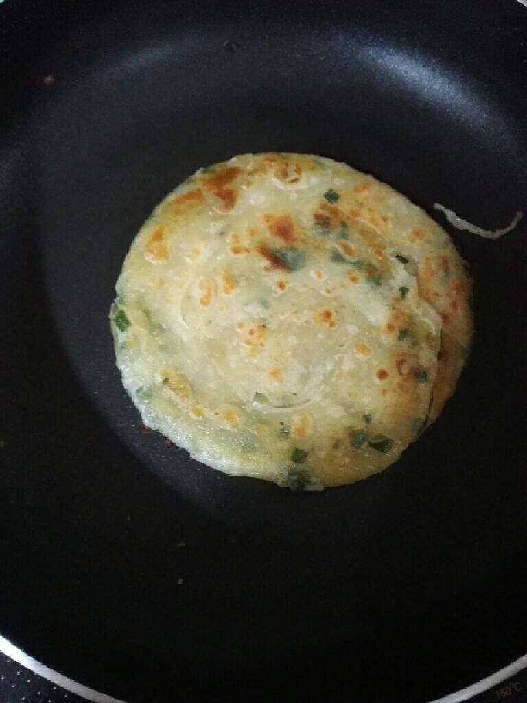 烫面葱花饼,锅加适量油,烧热,烙至两面金黄即可。(在饼差不多8成熟一边烙一边轻摔一下饼,这样更有层次酥脆)