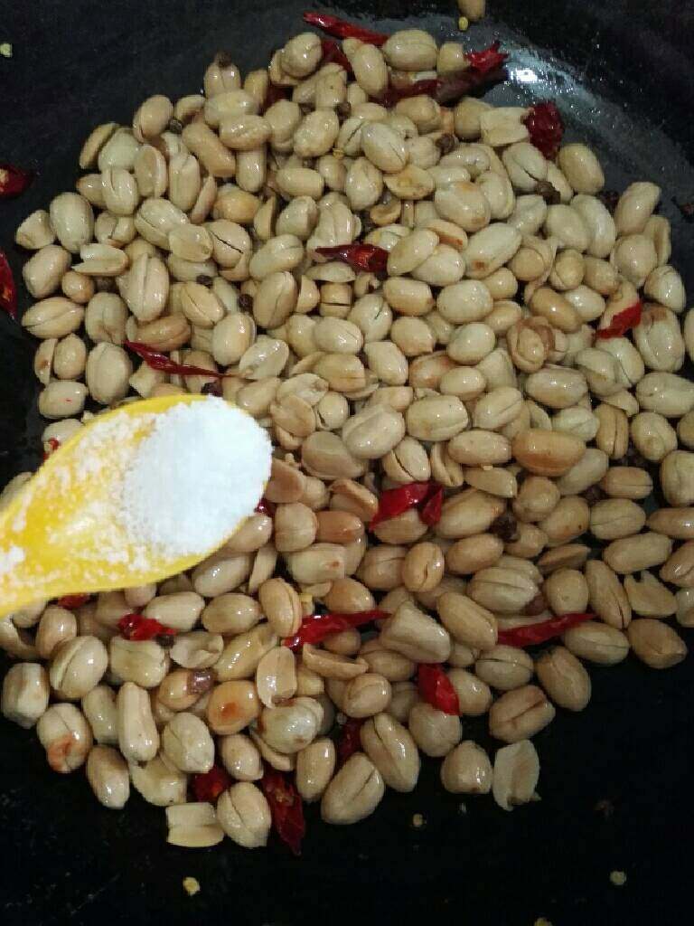 酒鬼花生,炒出麻香味时,倒入花生米,加入适量盐,白糖翻炒均匀。