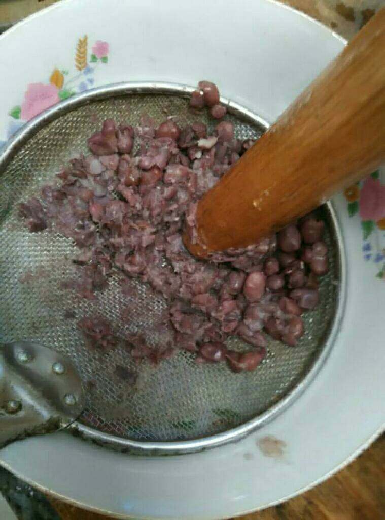 自制红豆沙。,红豆煮到一捻就碎,将红豆盛在漏网里,用擀面杖捻豆子,用勺子也可以,下面放个空碗,接豆沙