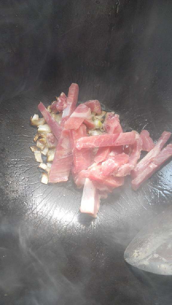 青椒蘑菇炒肉,锅内放油,葱花爆香,放入瘦肉炒至变色。