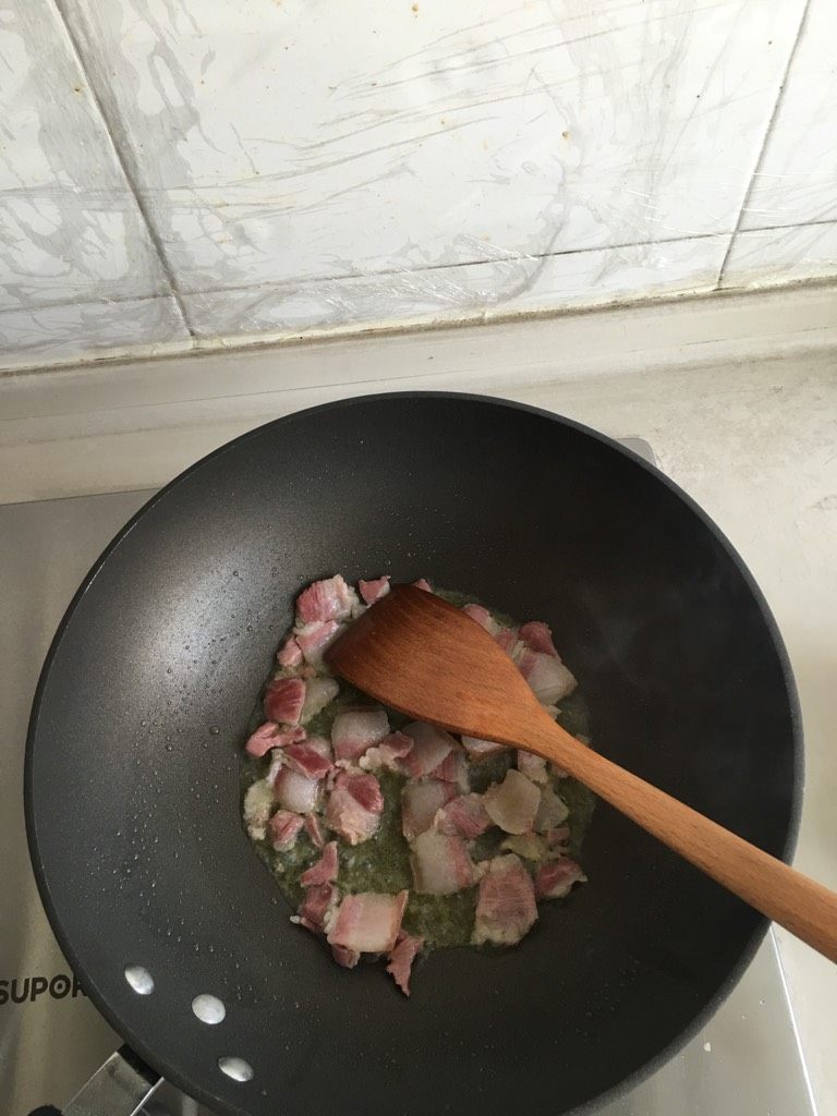 上海咸肉菜饭,倒入咸肉煸炒至熟。