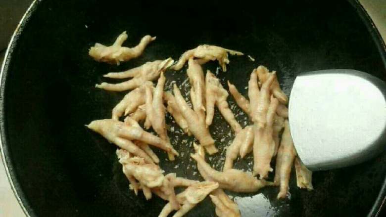爆炒鸡爪,锅里放油,我做荤菜用的是山茶油,炒出来会特别香、等油热后下鸡爪爆炒、要不停翻炒,以免沾锅