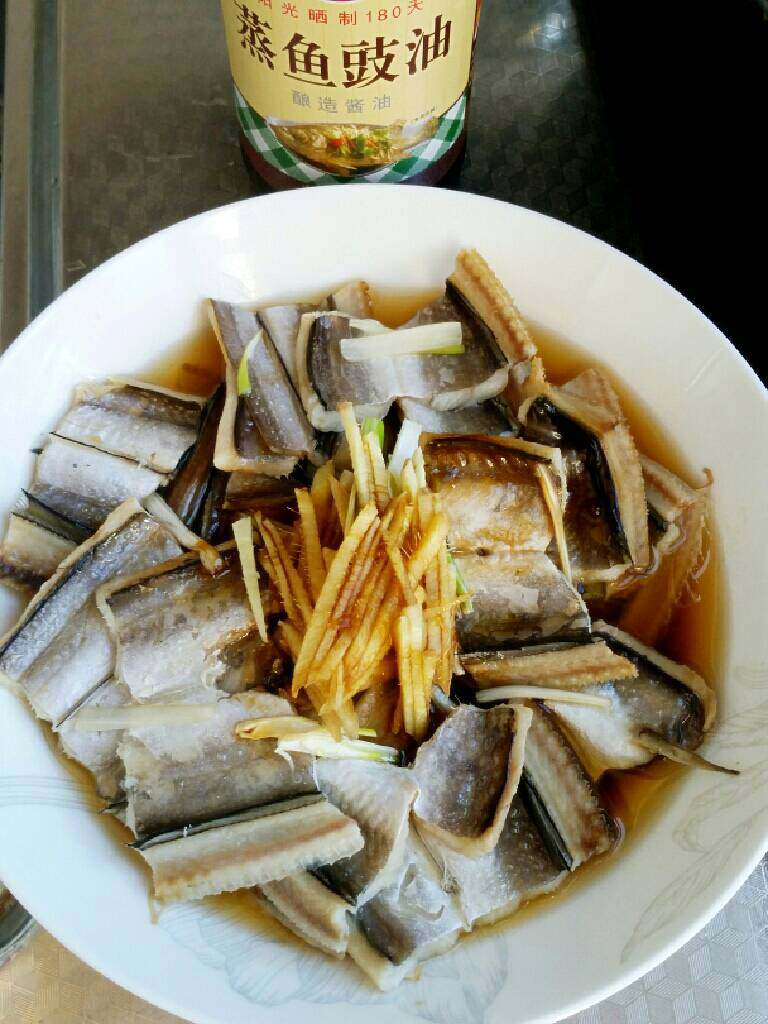 清蒸鳗鱼干,保鲜膜封好，上锅蒸，水开6分钟。蒸过的姜葱捡出，放入新的姜葱丝，竖椒，倒入鱼豉油。